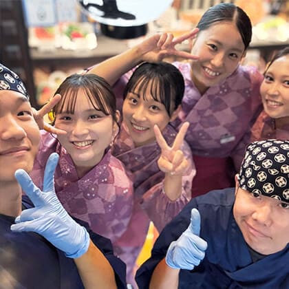 いろはかるた京都駅前店のアルバイトが複数人でピースサインをしている。